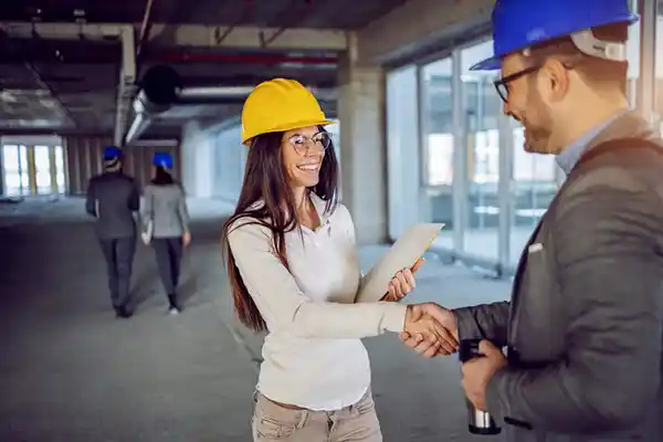 Arquitetos e engenheiros parceiros discutindo projeto de divisória de vidro com persiana